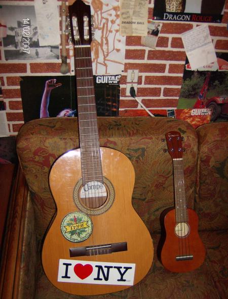 Guitare et bébé guitare sur fond de canapé moche.